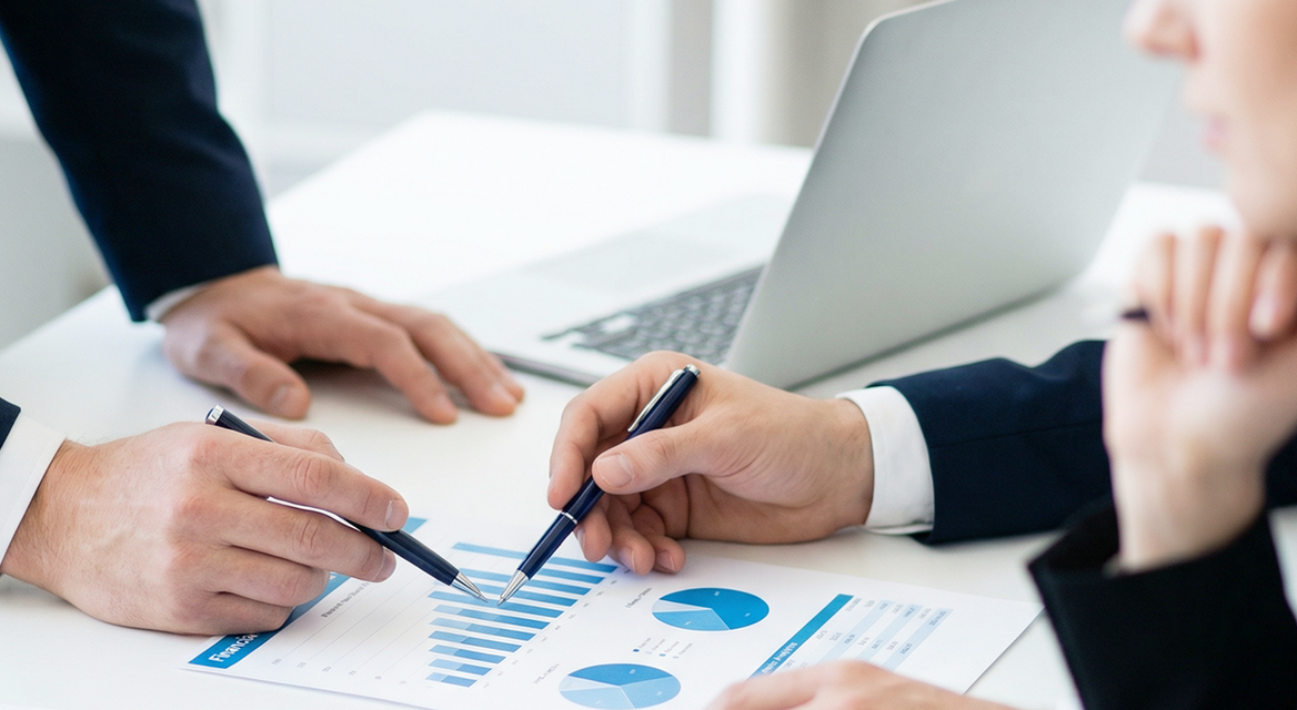 마케팅 회의 중 자료를 보며 논의하는 모습